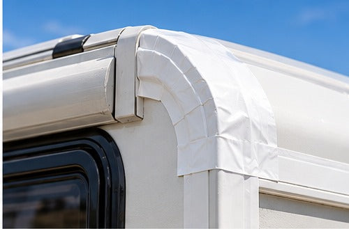 White tape sealing a caravan roof edge and trim joint