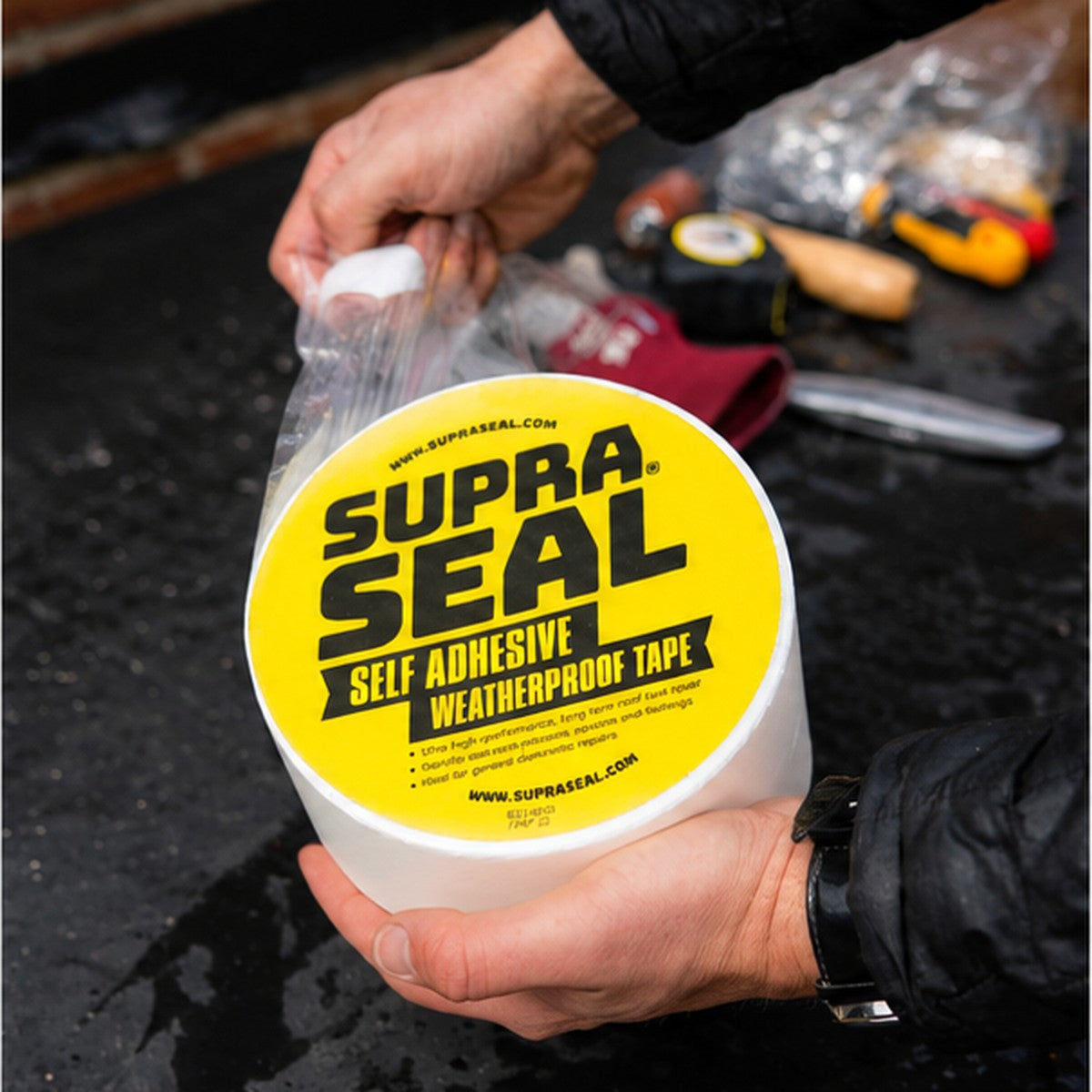 Unwrapping a roll of Supraseal white weatherproofing tape
